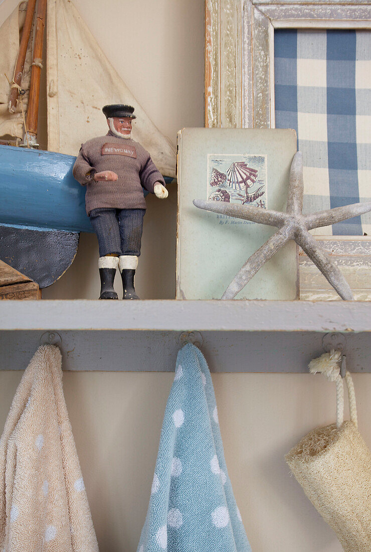 Toy boat and male figurine on bathroom shelf in Kent home England UK