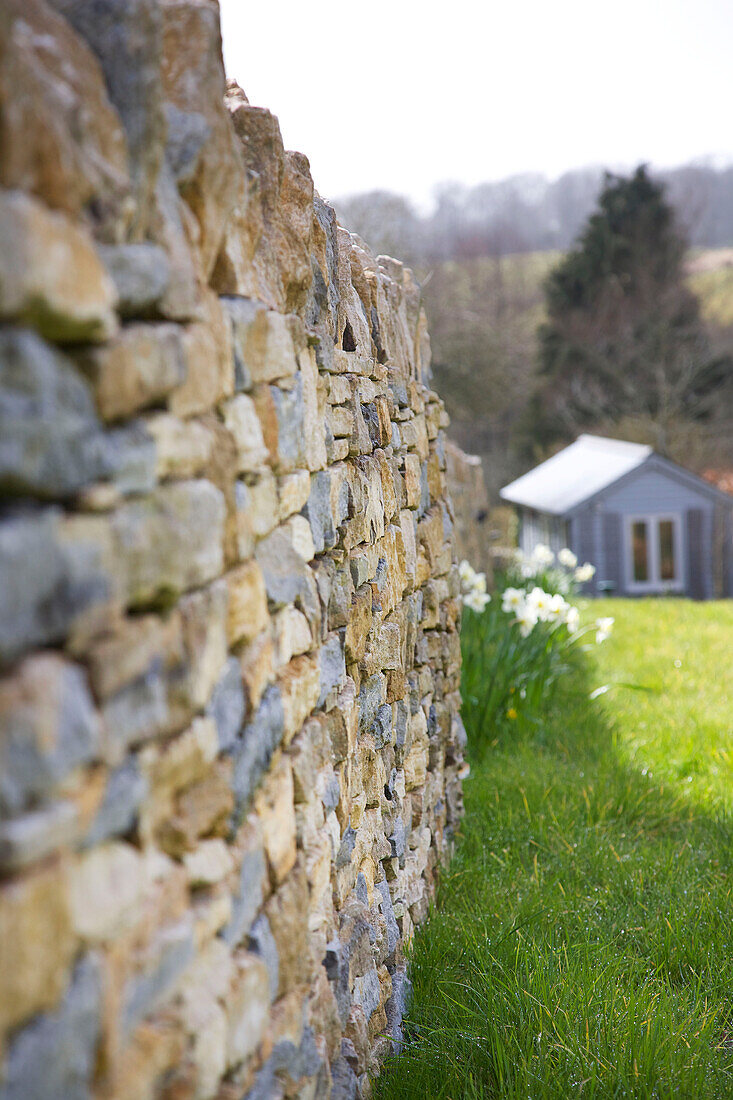 Dry-stone wall and garden shed in Dorset garden Corfe Castle England UK