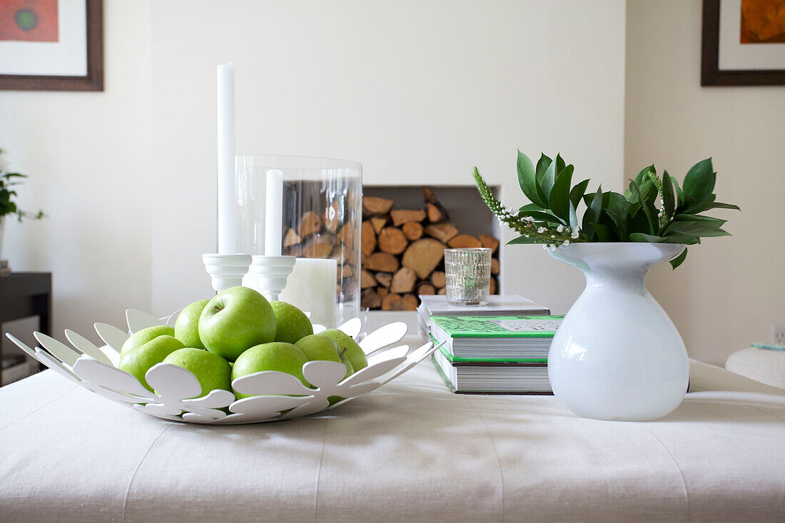 Fresh apples and leaf arrangement with firewood in Wandsworth home London England UK