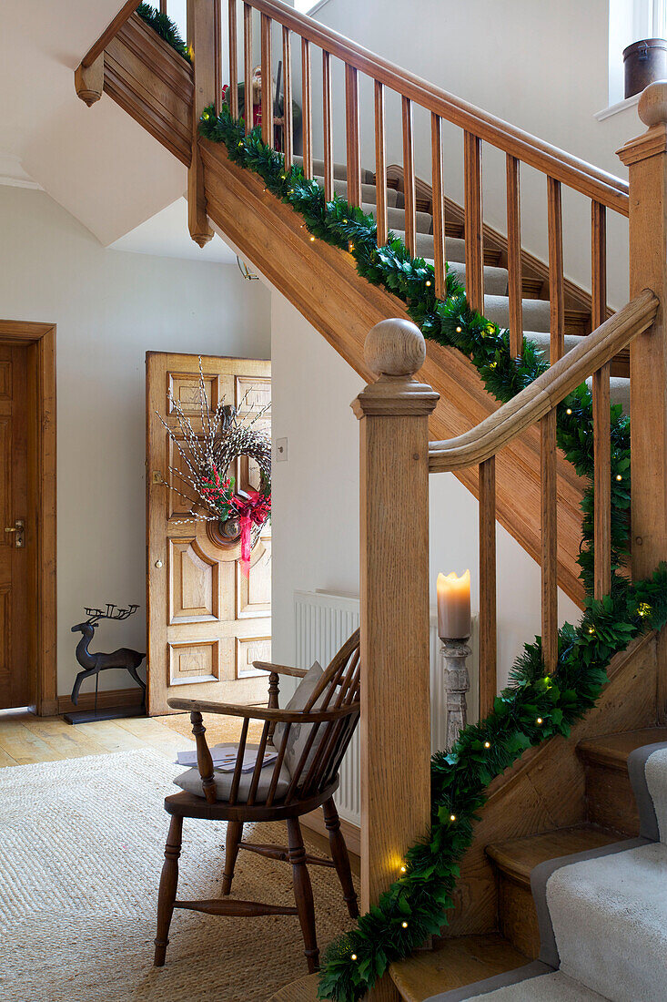 Christmas decorations with fairylights on wooden banister in Faversham entrance hallway Kent England UK