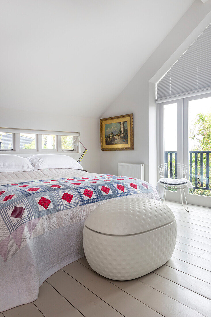 Laundry basket at foot of bed with patchwork quilt Rye East Sussex UK