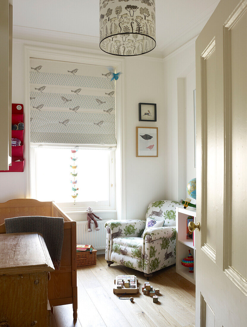 Building blocks on nursery floor with upholstered armchair in London home England UK