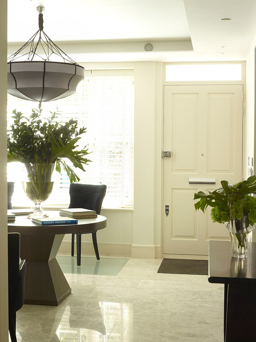 Leaf arrangement on pedestal table in entrance room of London townhouse, UK