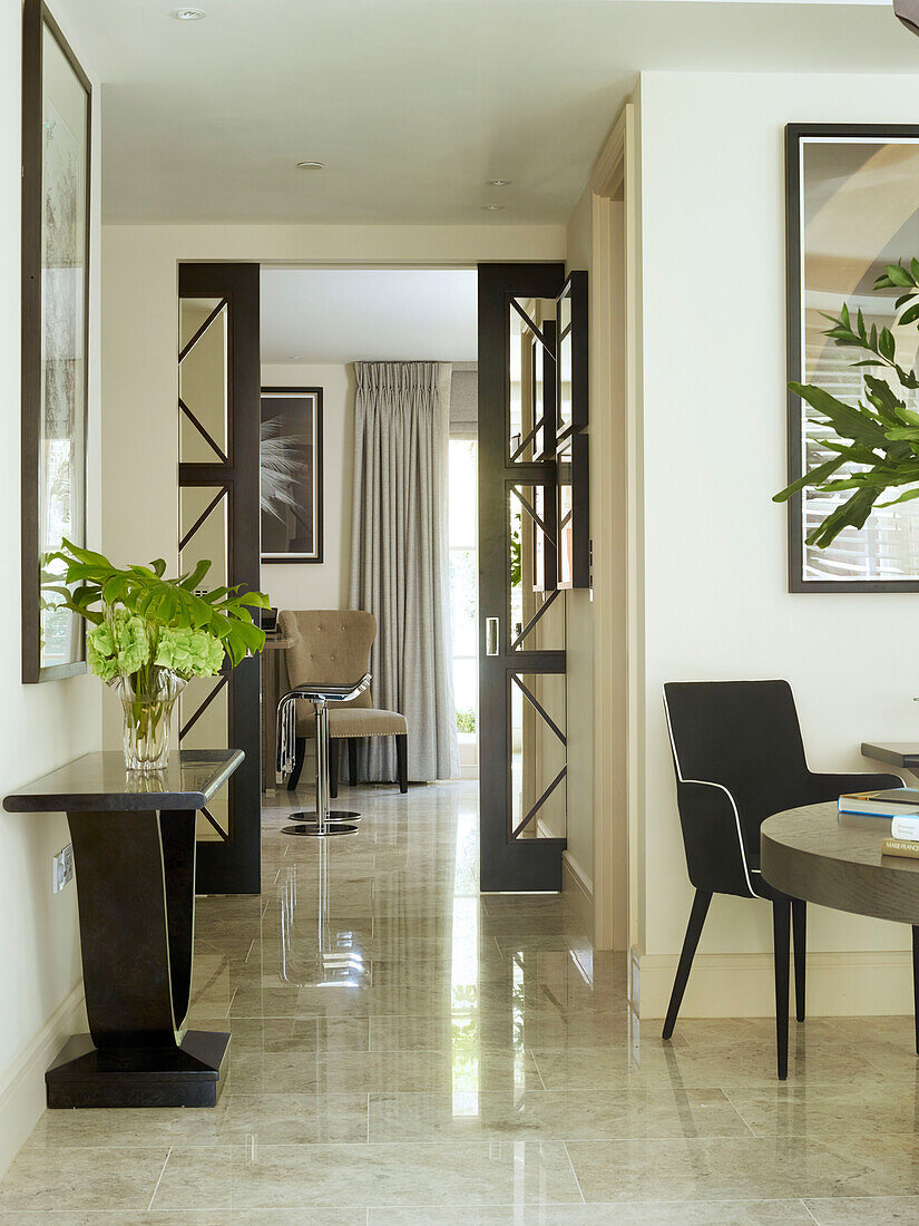 Leaf arrangement on dark wood console in London townhouse, UK