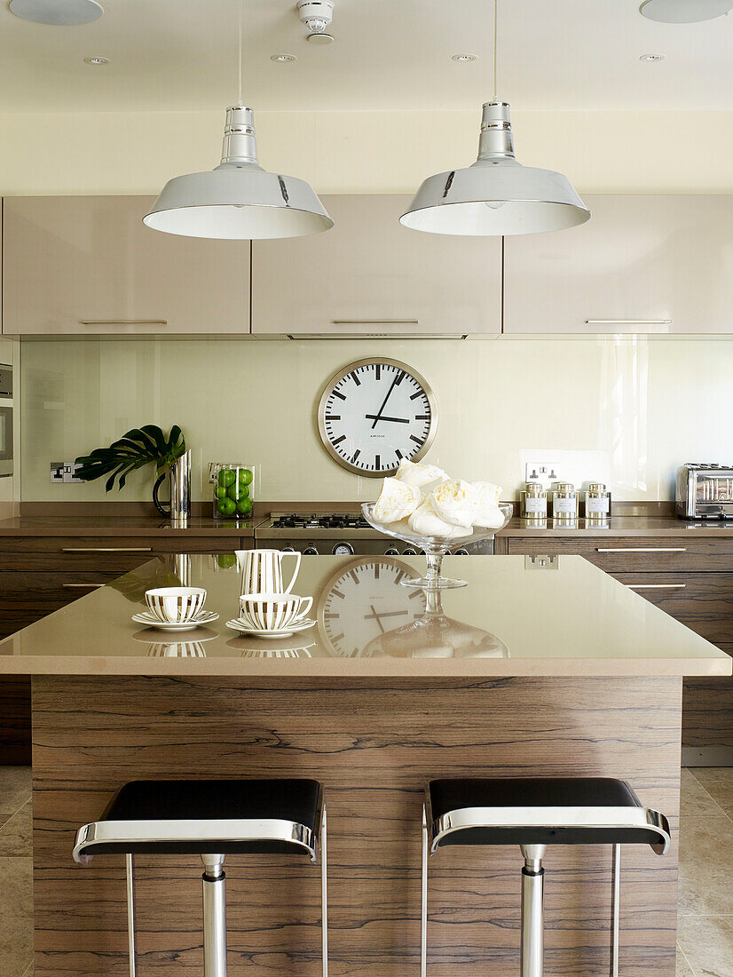 Meringues and crockery on island unit in kitchen of London townhouse, UK