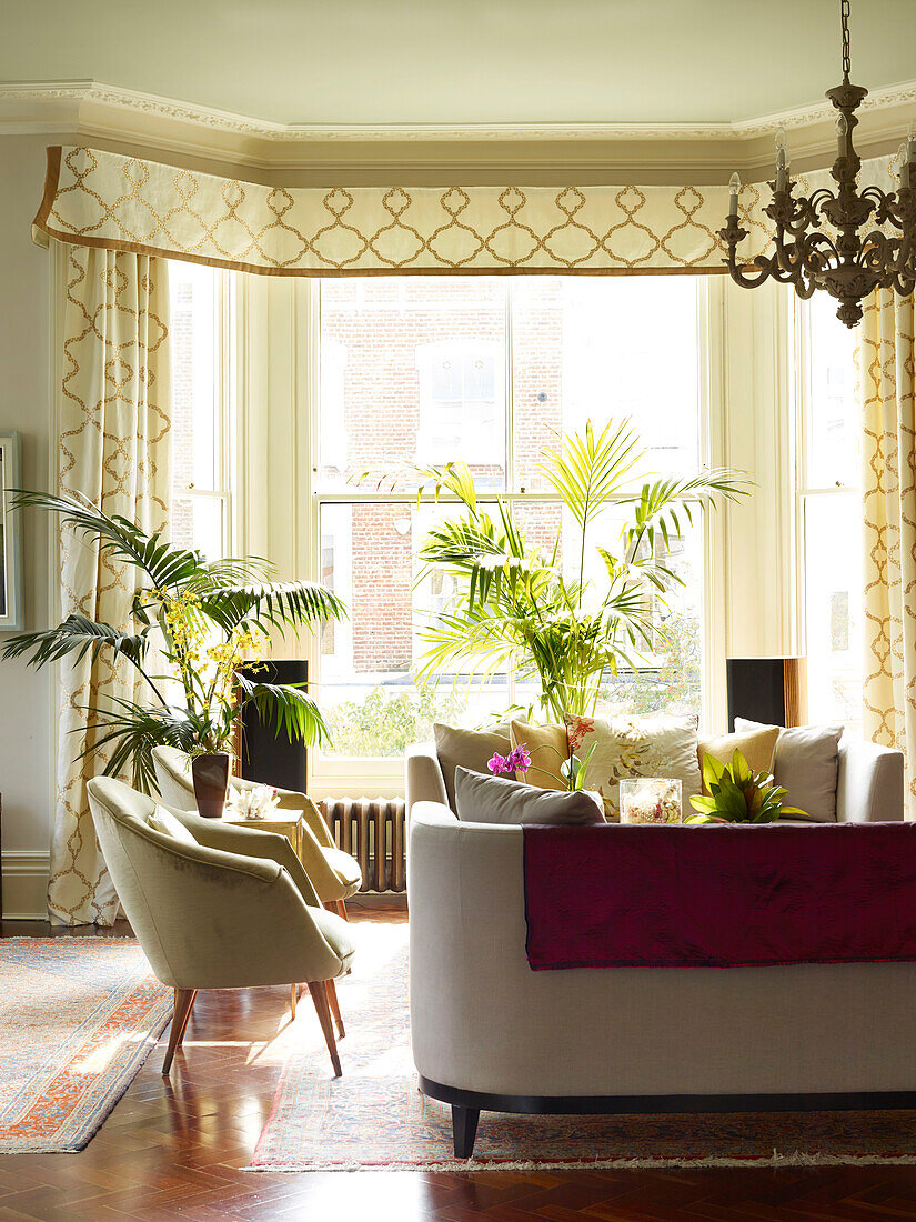 Pair of armchairs and sofa in living room of London townhouse apartment, UK