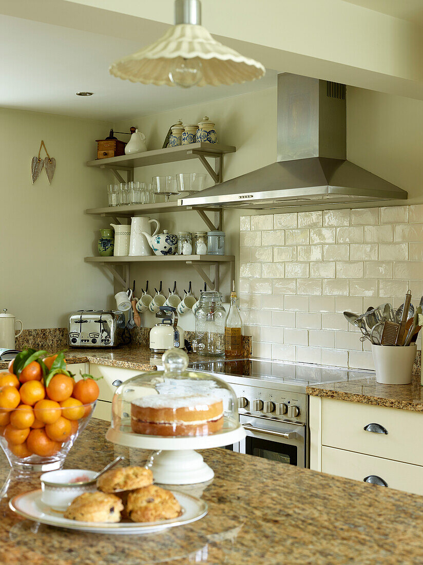 Biskuitkuchen und Satsumas auf einer Marmorarbeitsplatte in einer Küche in Oxfordshire, England, Vereinigtes Königreich