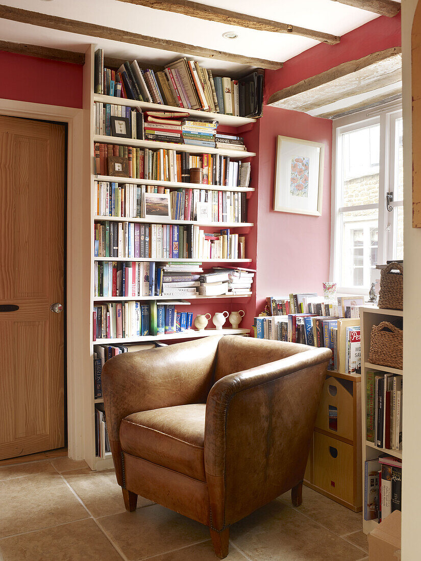 Braunes Ledersofa und Bücherregal in einem Haus in Nottinghamshire England UK