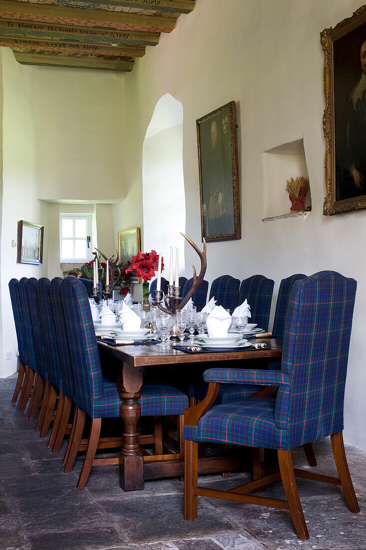 Blue tartan dining chairs at set table in Scottish home UK