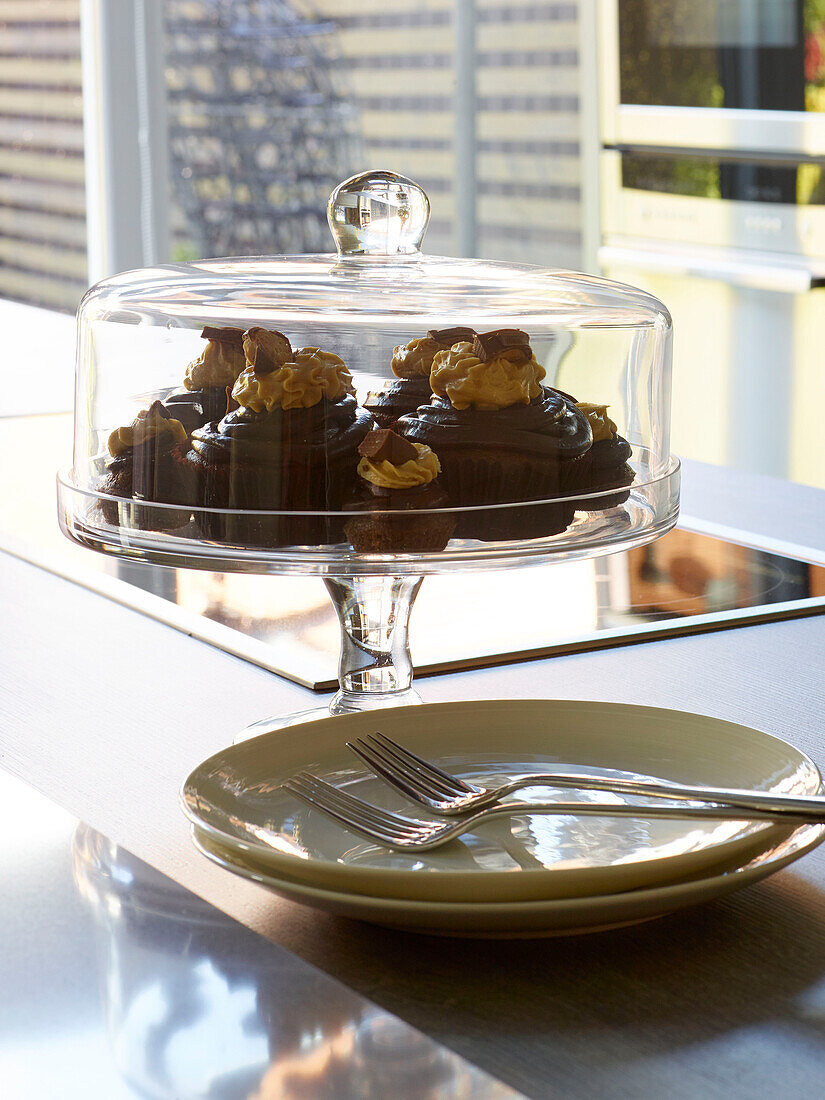 Chocolate cupcakes with forks and side plates on worktop in Manchester home, England, UK