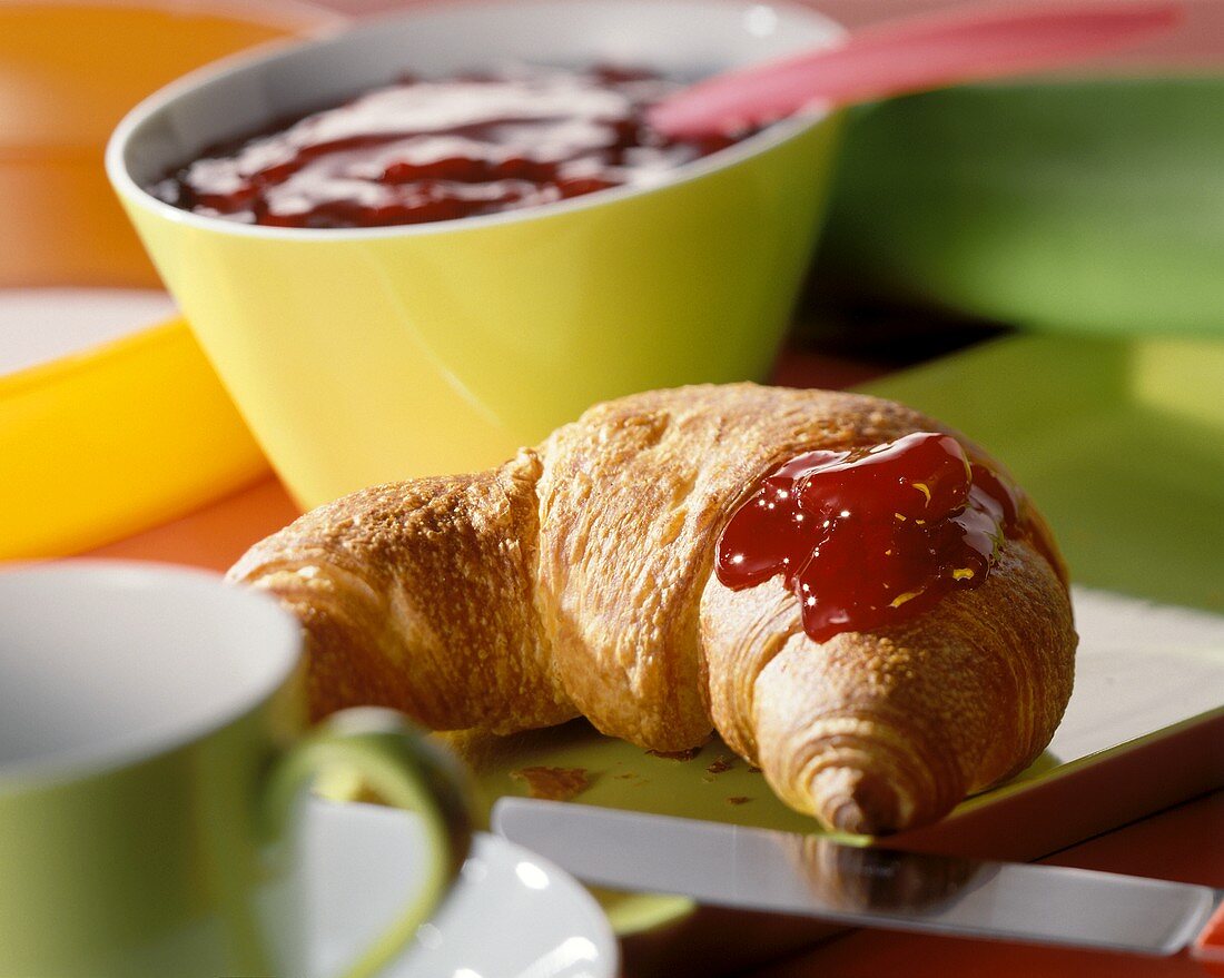 A croissant with red jam