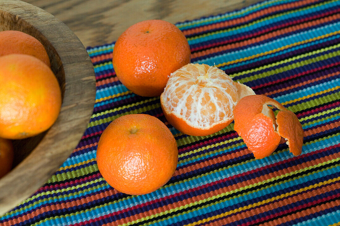 Peeled Satsuma on multi-coloured table mat in London home UK