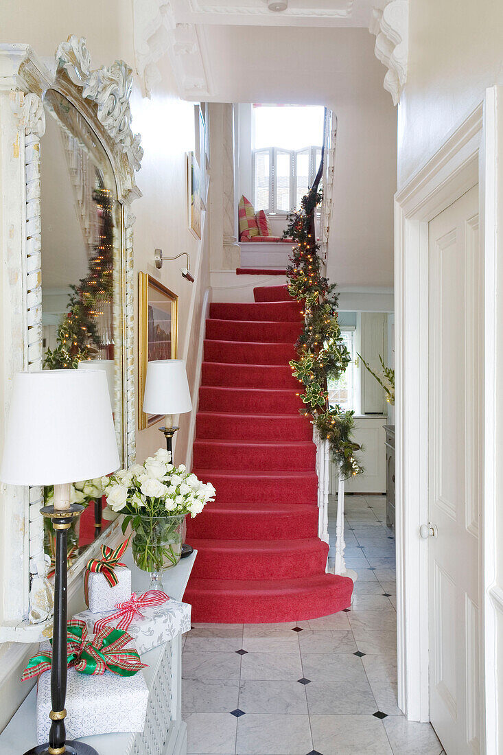 Pink carpeted hallway with Christmas garlands in London home UK