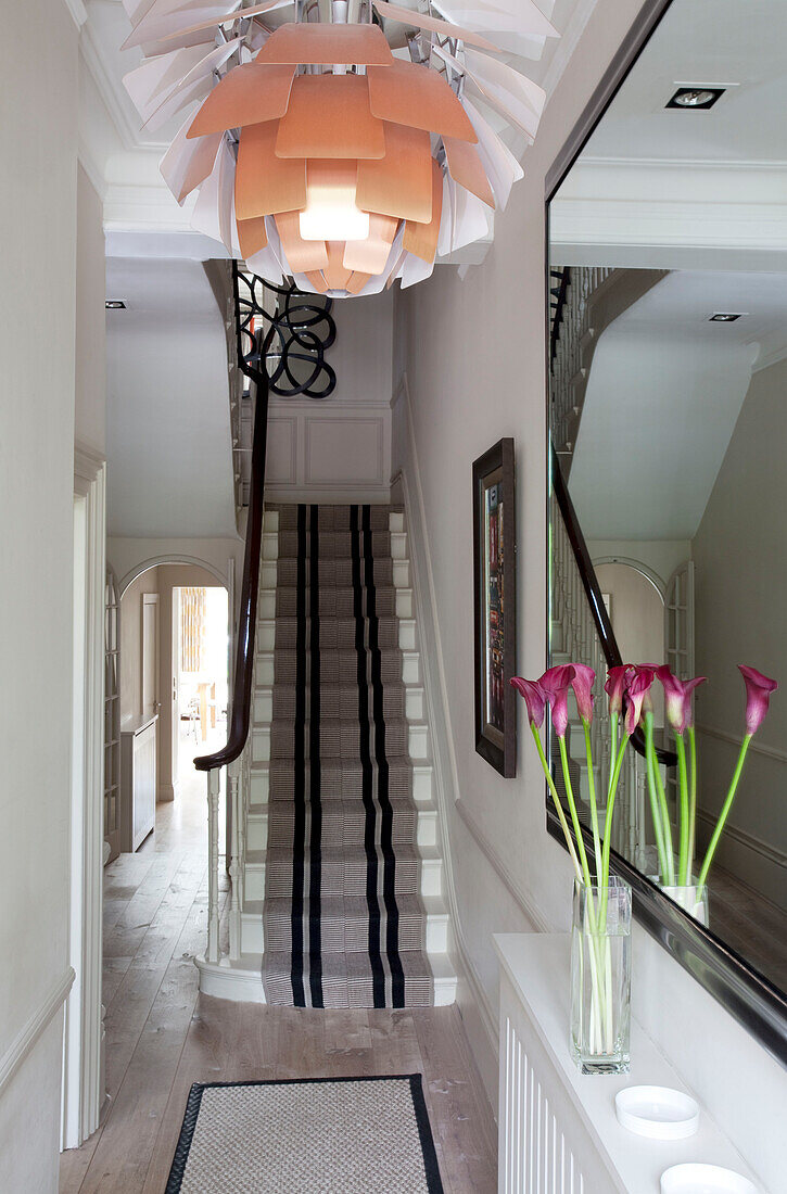 Floral ceiling lampshade in hallway of contemporary London home with carpeted staircase, UK