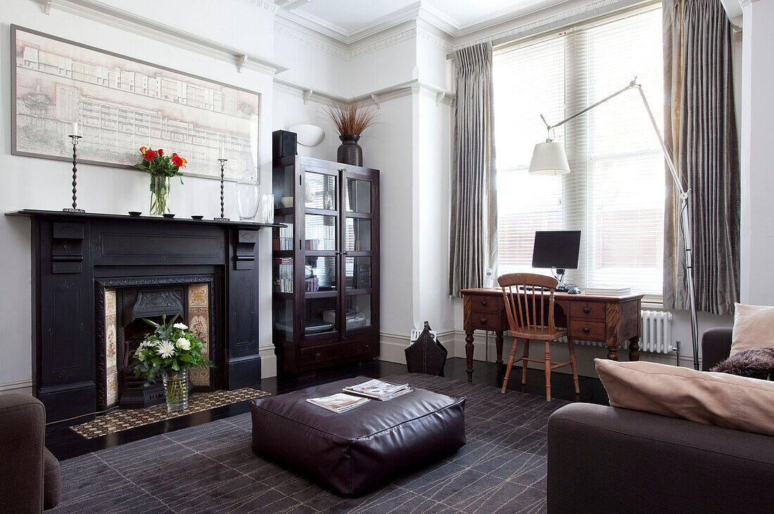 Large fireplace in contemporary living room of Hove home with desk at window, East Sussex, England, UK