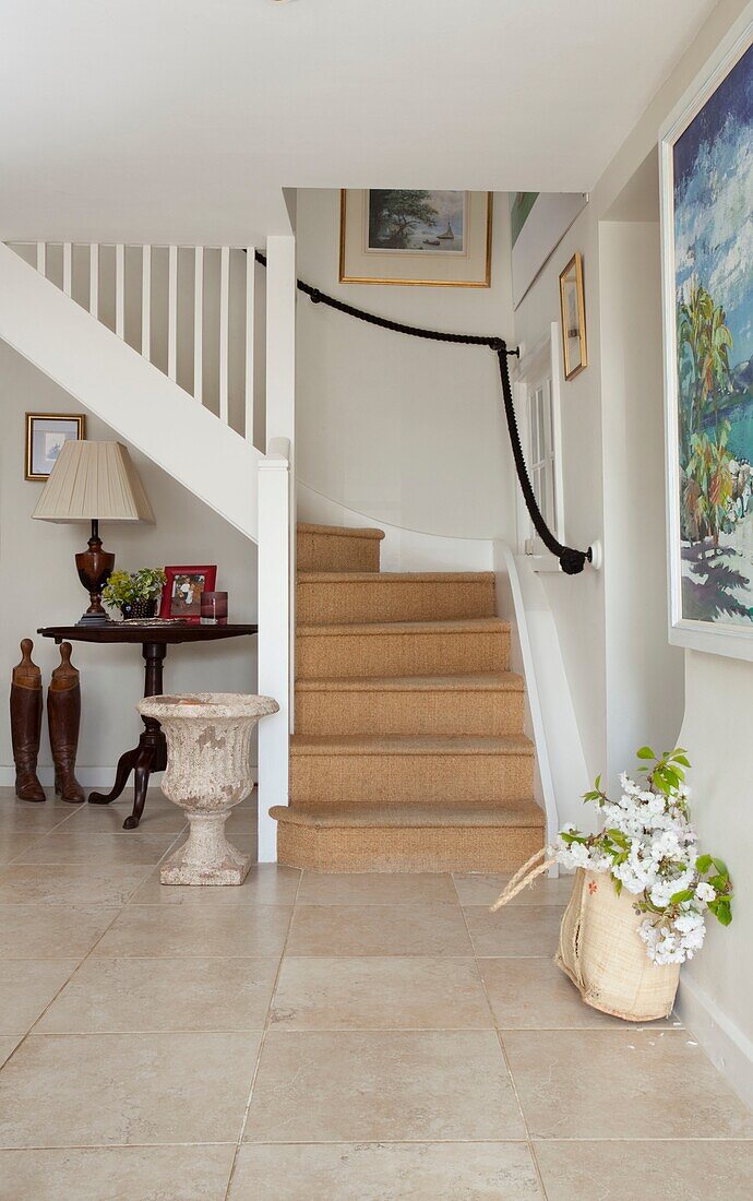 Schnittblumen in Tasche und Treppe mit Kokosfasermatten in einem Haus in Kent, England, UK