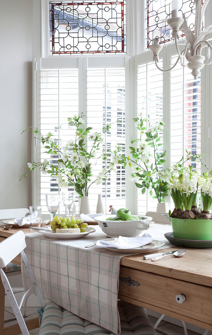 Cut flowers and tableware on window of Surrey home, England, UK