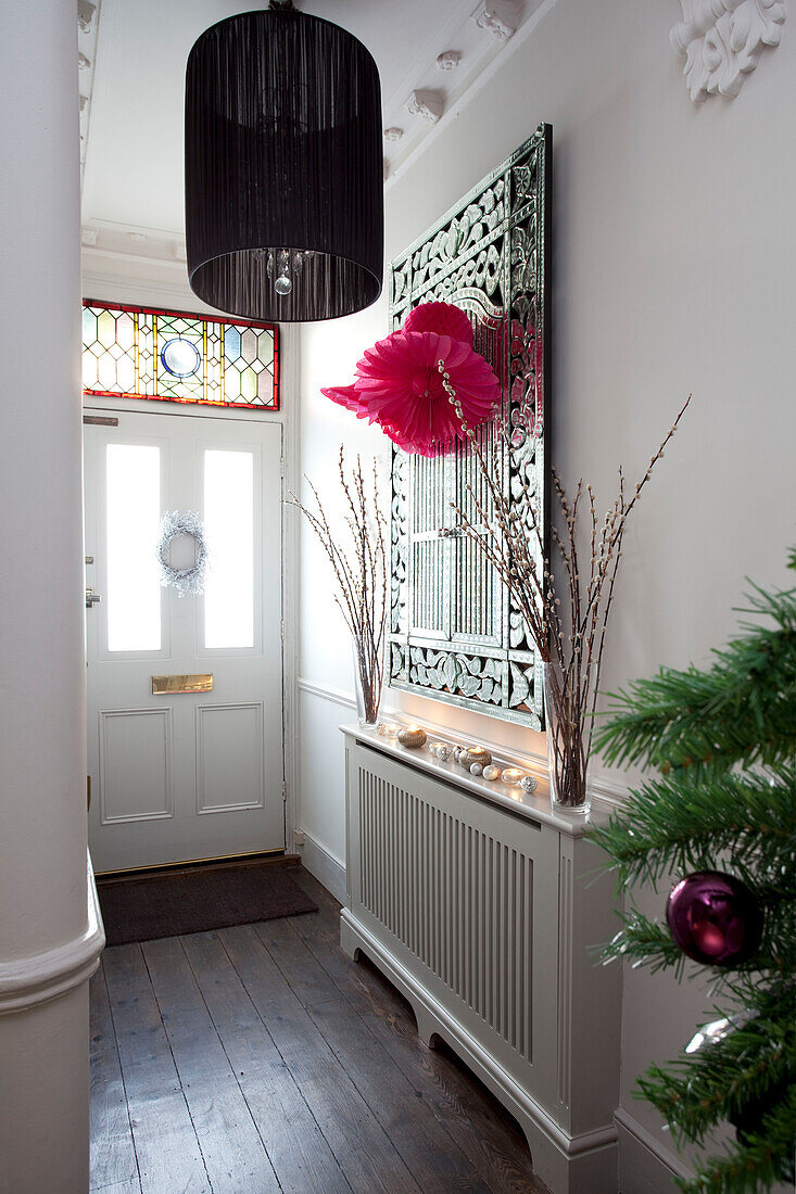 Decorative mirror above radiator in contemporary hallway of London home, UK