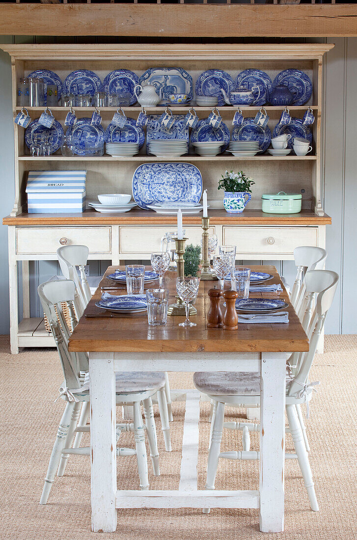 Dining table set for four with blue and white chinaware in kitchen dresser Kent farmhouse England UK