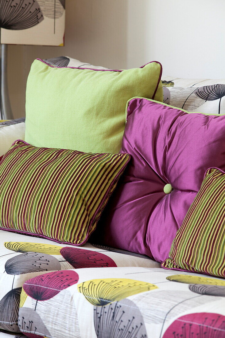 Pink and green cushions on sofa in living room of contemporary London townhouse, England, UK