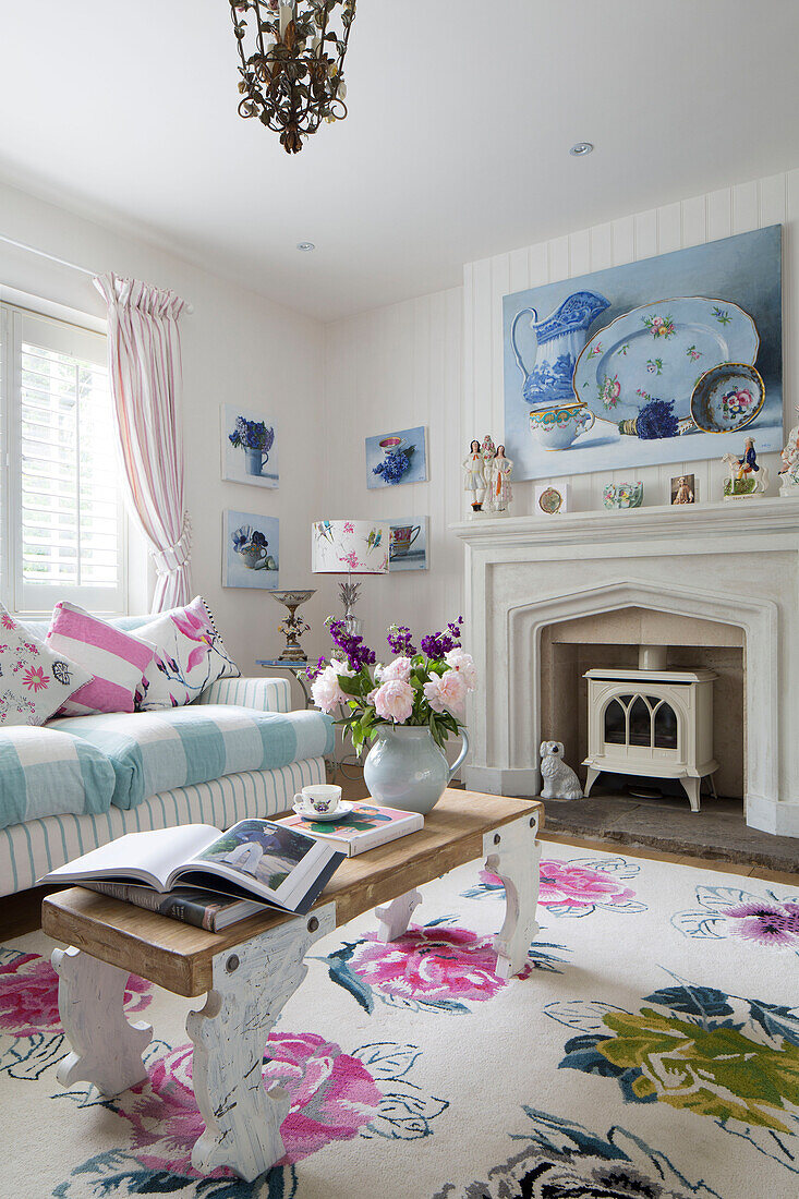 Schnittblumen und Bücher auf einem Couchtisch im Wohnzimmer mit verschiedenen Stoffen in einem Haus in Dulwich, London, England, UK