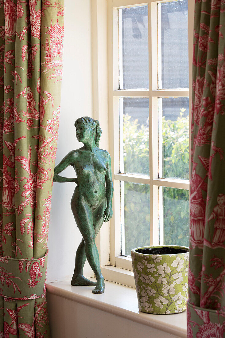 Figurine of naked woman with flowerpot on windowsill in Sussex home England UK
