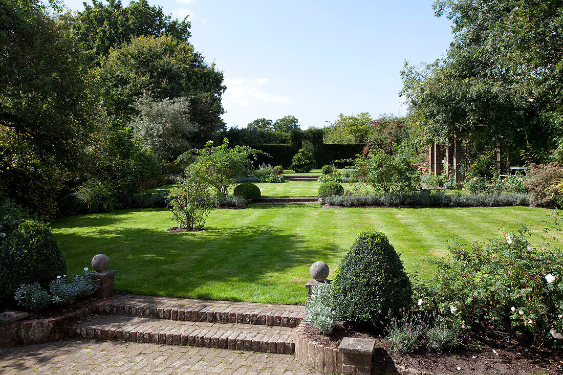 Lawned garden exterior of Sussex farmhouse, England, UK