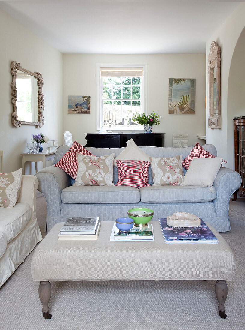 Hellblaues Sofa und Ottomane im Wohnzimmer eines Landhauses in Sussex, England, UK