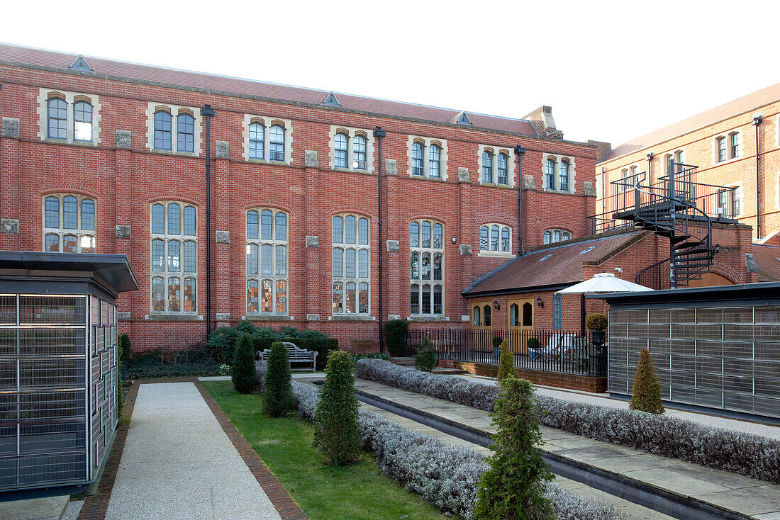 Landscaped garden and brick facade of warehouse conversion in Berkshire, England, UK