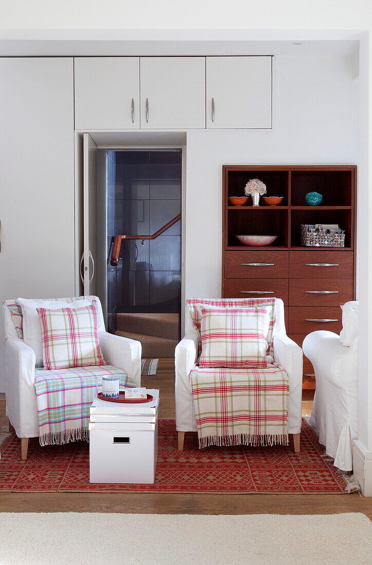 Matching armchairs with blankets in living room of contemporary London townhouse, England, UK