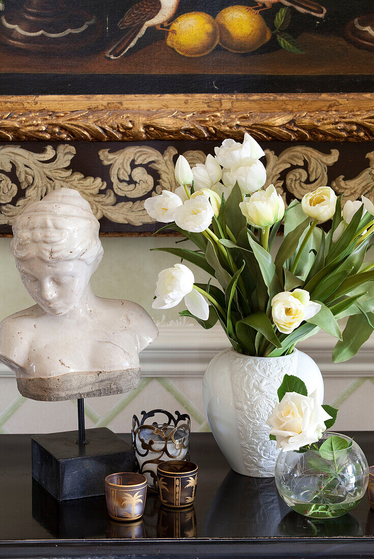 Antike Büste und Teelichter mit geschnittenen Tulpen in einem Landhaus in Sussex, England, UK