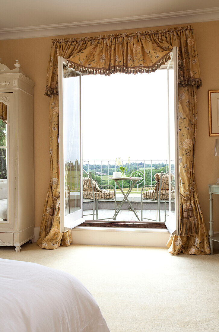 Blick durch eine offene Tür auf einen Balkon in einem Landhaus in Sussex, England, UK