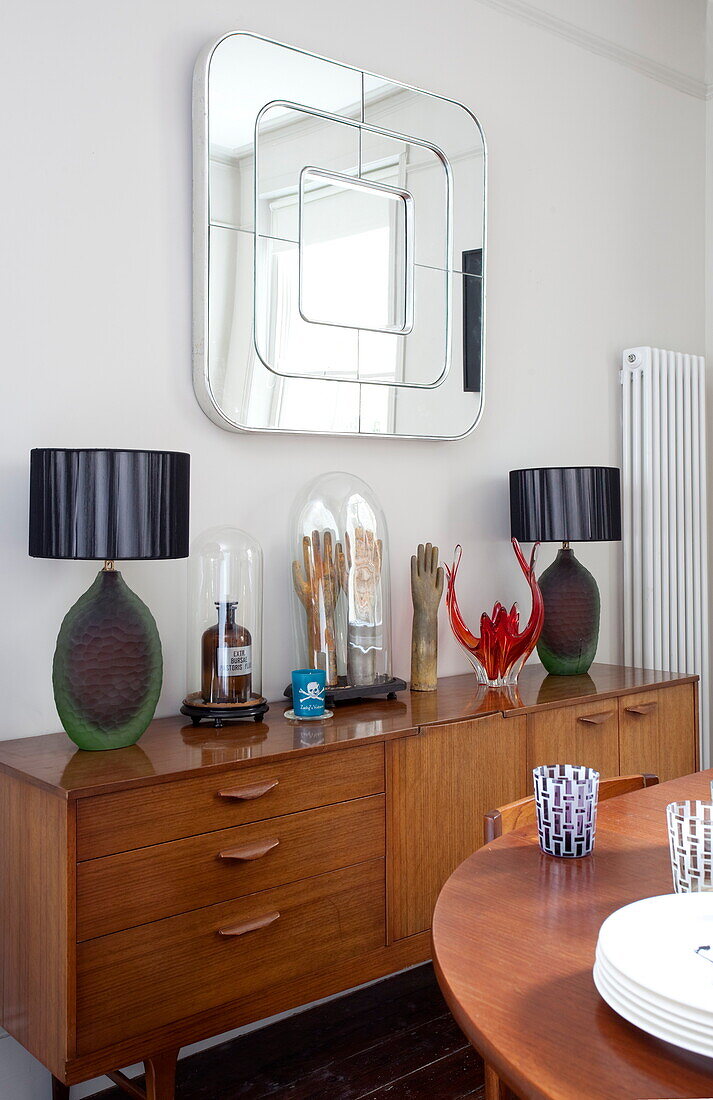 Vintage wooden sideboard and table with square mirror in London townhouse, England, UK