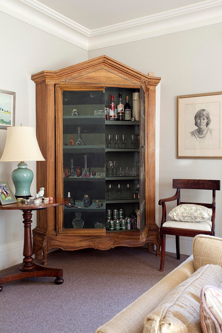 Antique wooden drinks cabinet with side table and chair in Kent home England UK