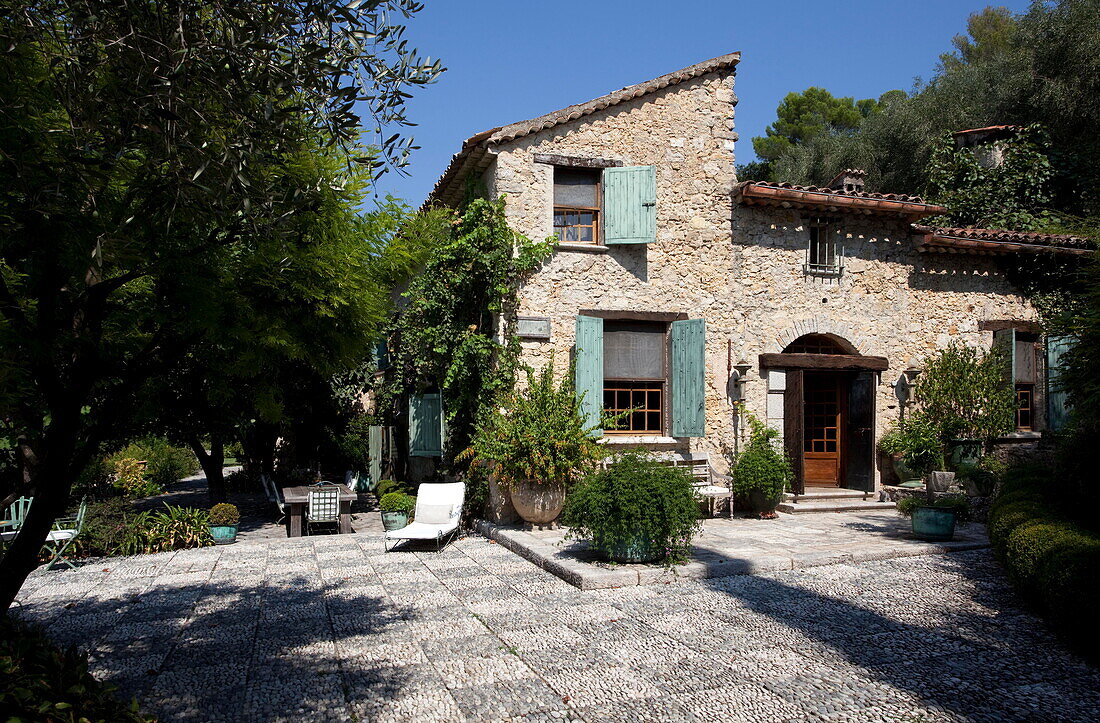 Sunlit patio terrace of shuttered French holiday villa