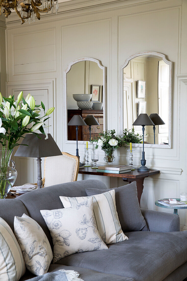 Cream cushions on grey sofa in living room with a pair of mirrors in Wells next the Sea home Norfolk England UK