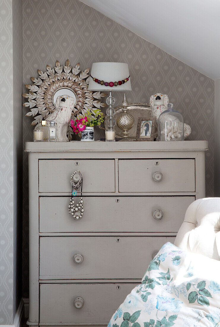 Ornaments on painted chest of drawers in attic bedroom of Dorset cottage, England, UK