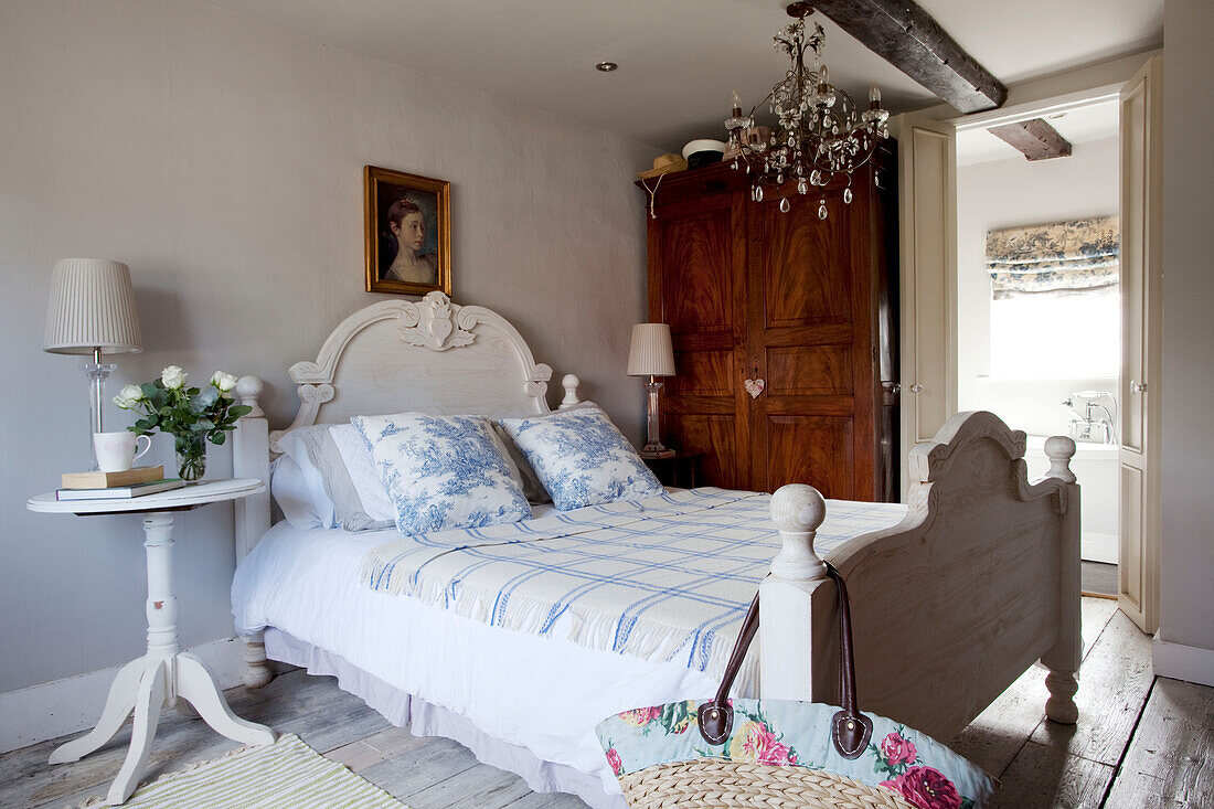 Toile du Jouy-Kissen auf einem Doppelbett mit Holzschrank in einem Schlafzimmer in West Sussex, England, Vereinigtes Königreich