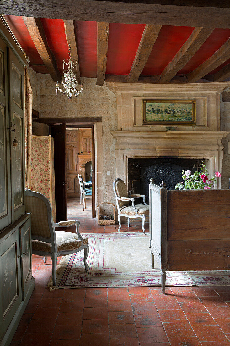 Rote Balkendecke in einem Wohnzimmer aus Naturstein in einem französischen Bauernhaus an der Loire, Frankreich, Europa