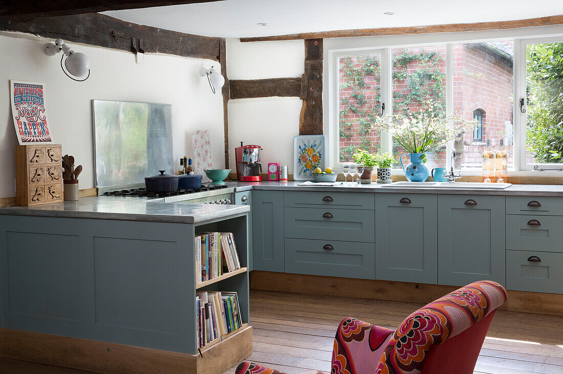 Spritzschutz aus Edelstahl in offener, hellblauer Einbauküche in einem Haus in Herefordshire, England, Vereinigtes Königreich