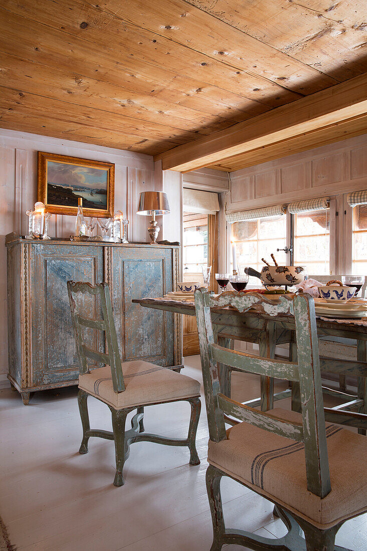 Esstisch und Beistellschrank unter der Holzdecke in einem Bergchalet in Chateau-d'Oex, Waadt, Schweiz