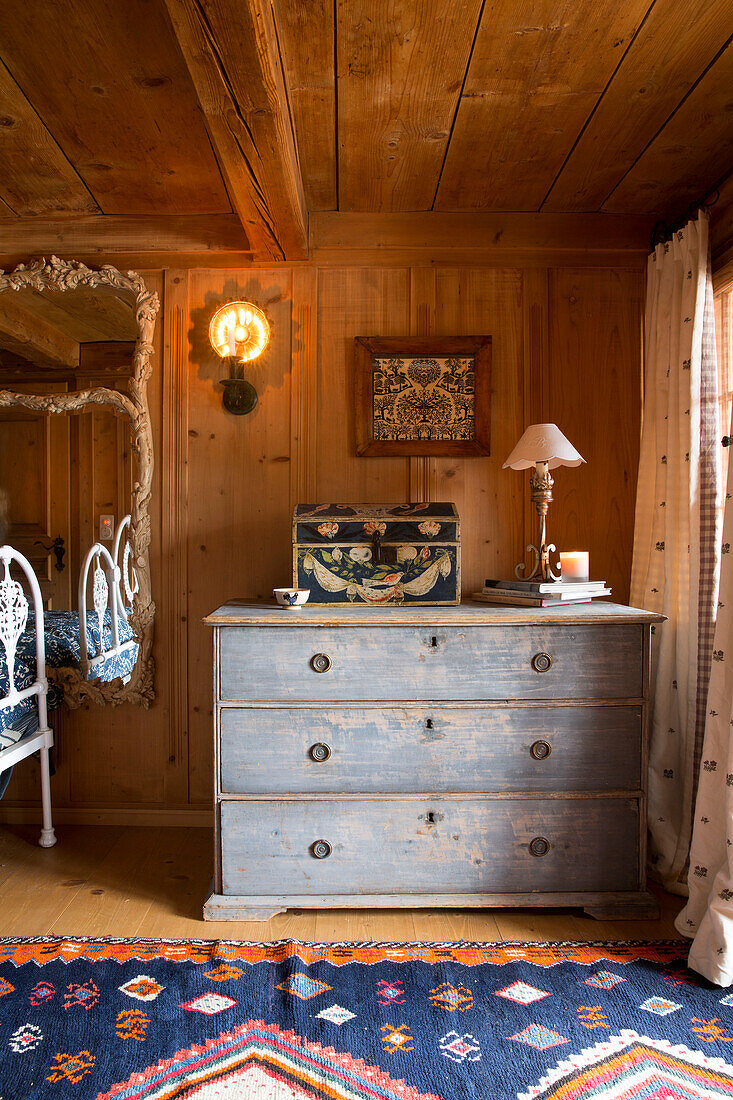 Light blue chest of drawers in wood panelled bedroom of mountain chalet, Chateau-d'Oex, Vaud, Switzerland