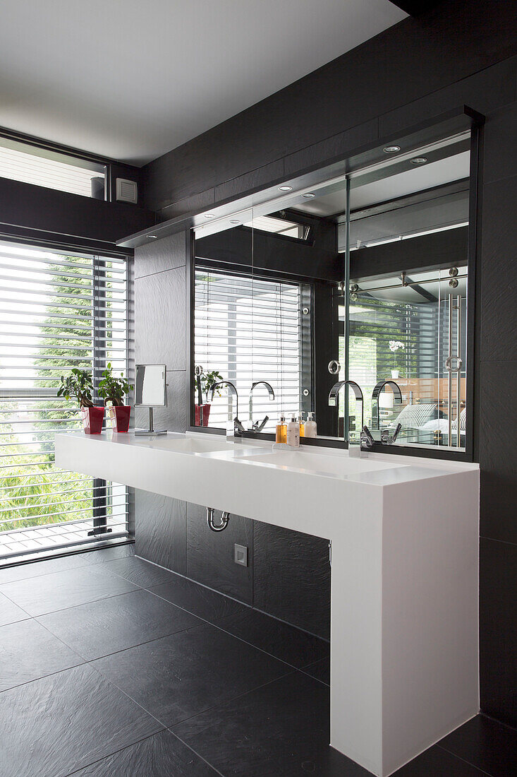 White wash stand with mirror at window in contemporary SW London home, England, UK