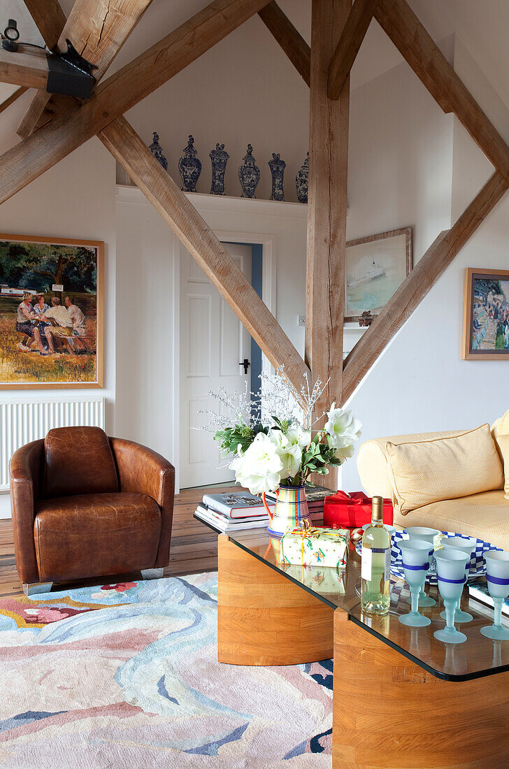 Glass topped coffee table with brown armchair in timber framed Chilterns home, England, UK