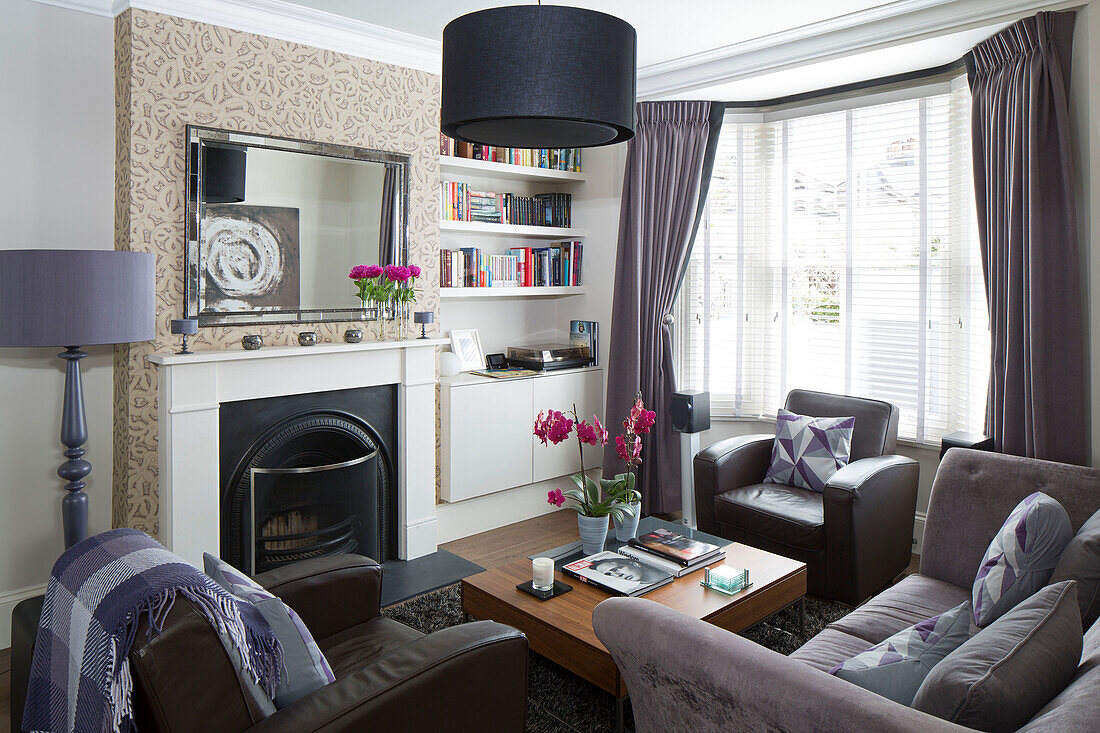 Black lampshade above low coffee table in contemporary living room of Brighton home East Sussex England UK