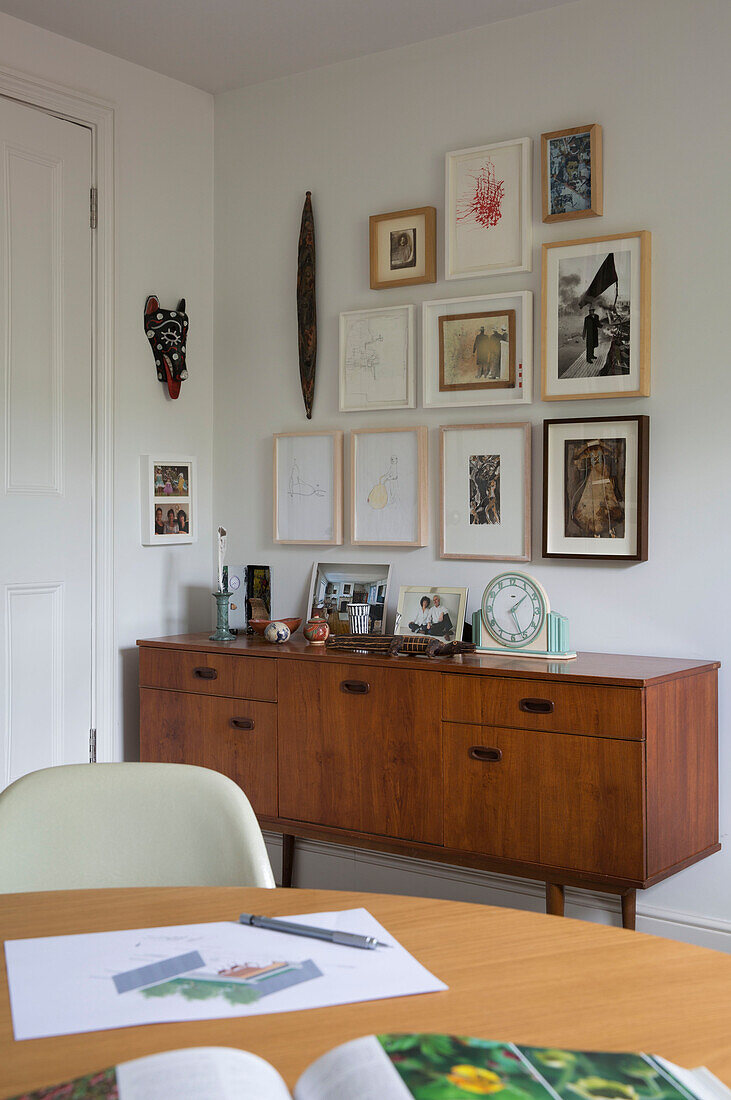 Framed artwork above wooden sideboard in Oxfordshire home England UK