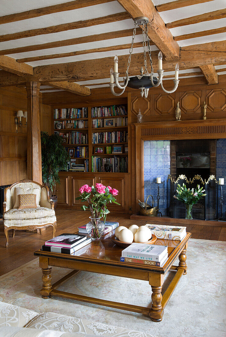 Wood panelled living room with low coffee table and tiled fireplace in London home, UK