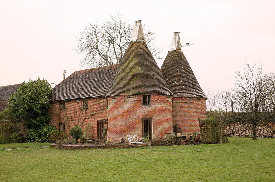 Lawned exterior of brick Suffolk farm building,  England,  UK