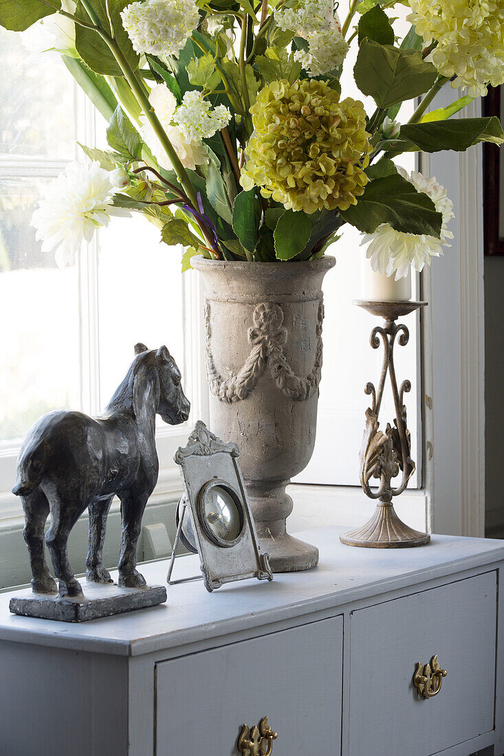 Ornamente und Schnittblumen auf Beistellschrank in Haus in Berkshire, England, UK