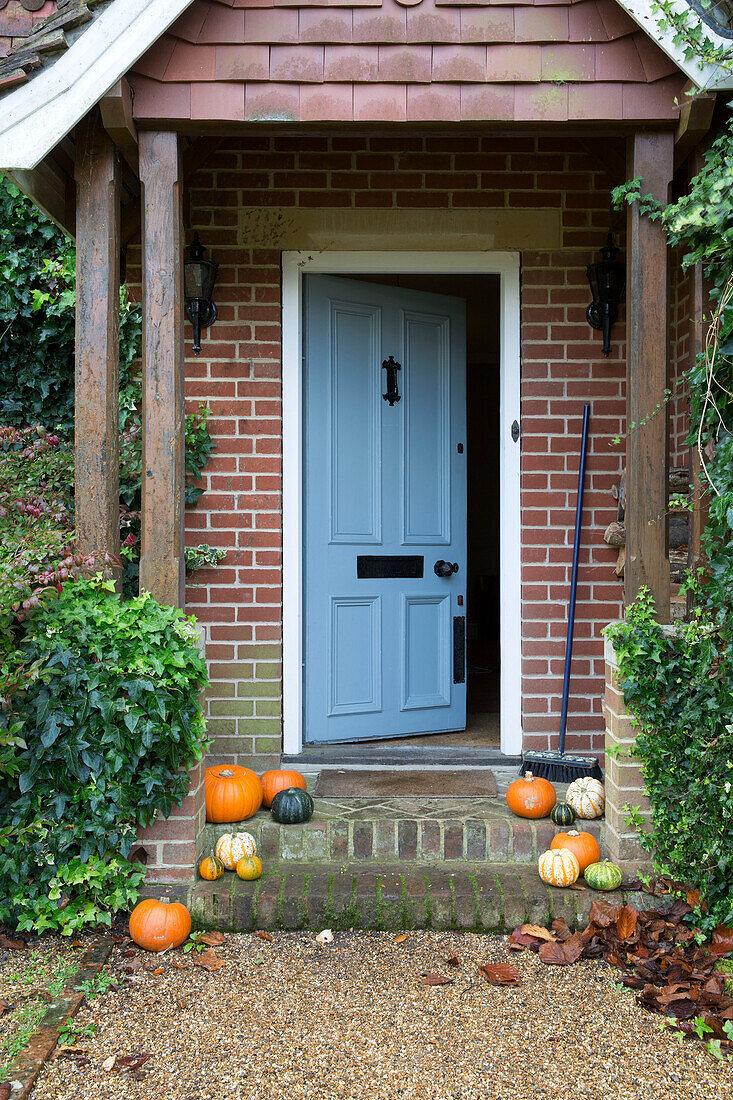 Pumpkins on doorstep in brick porchway of London home,  England,  UK